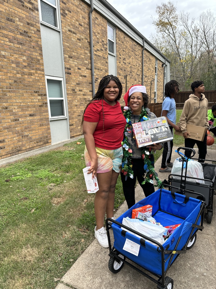 A ministry volunteer giving a holiday gift to a young community member