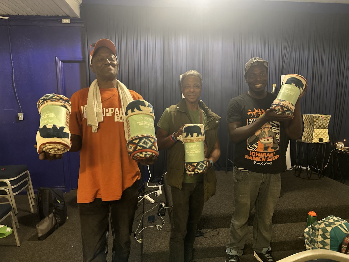 Community members holding new warm blankets